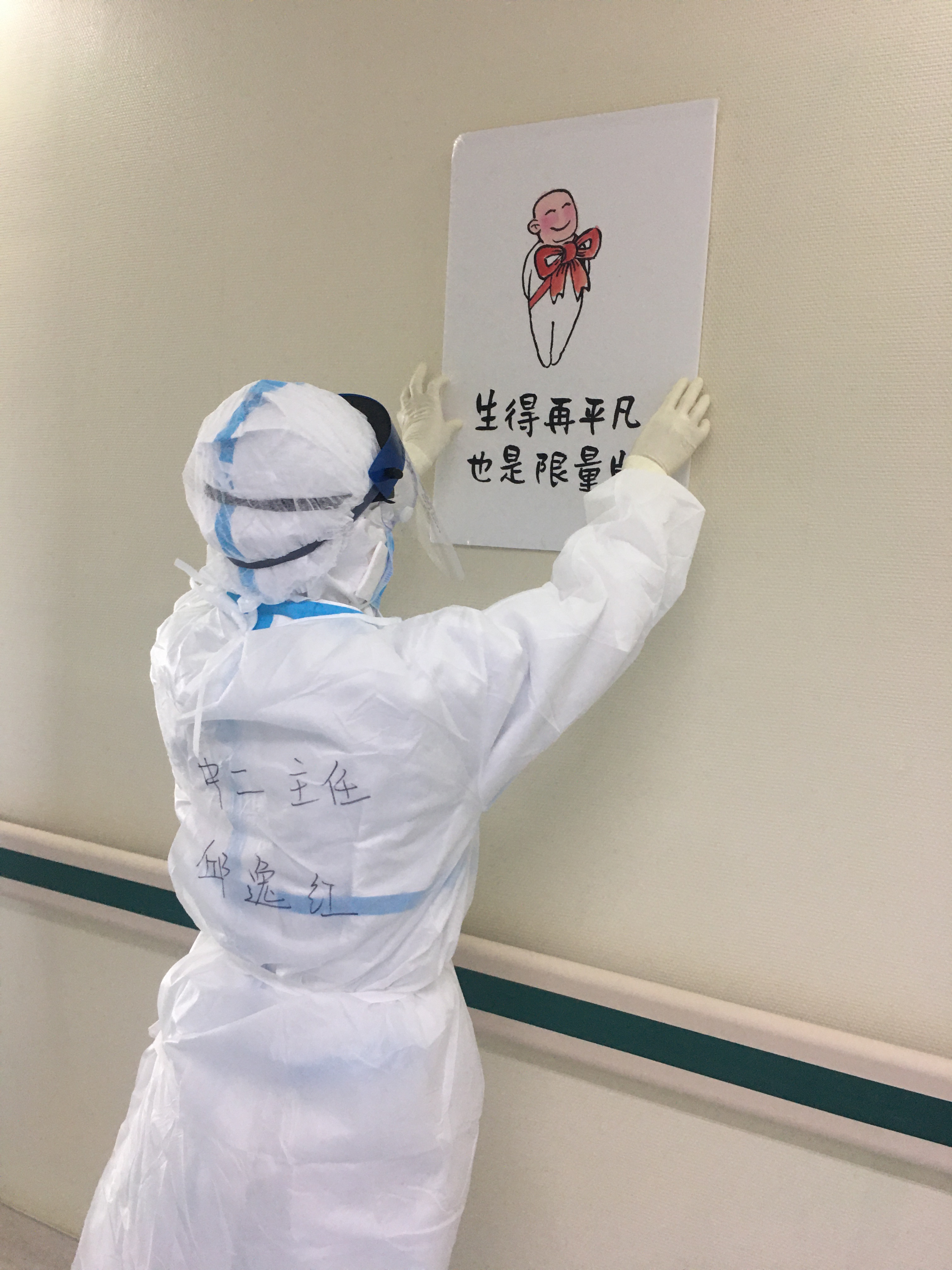 邱逸红在病区走廊贴上治愈系漫画，营造温馨的病区环境.jpg